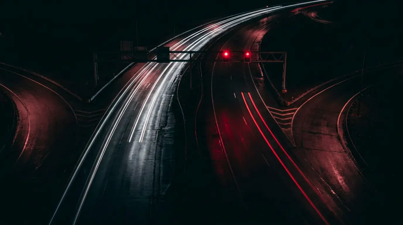 Headlight trails crossing an empty interstate interchange at night